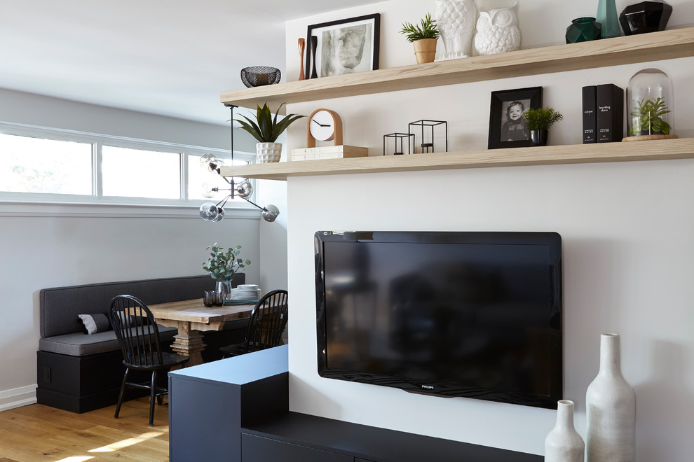 Modelo de salón abierto contemporáneo de tamaño medio sin chimenea con suelo marrón, paredes blancas, suelo de madera en tonos medios y televisor colgado en la pared