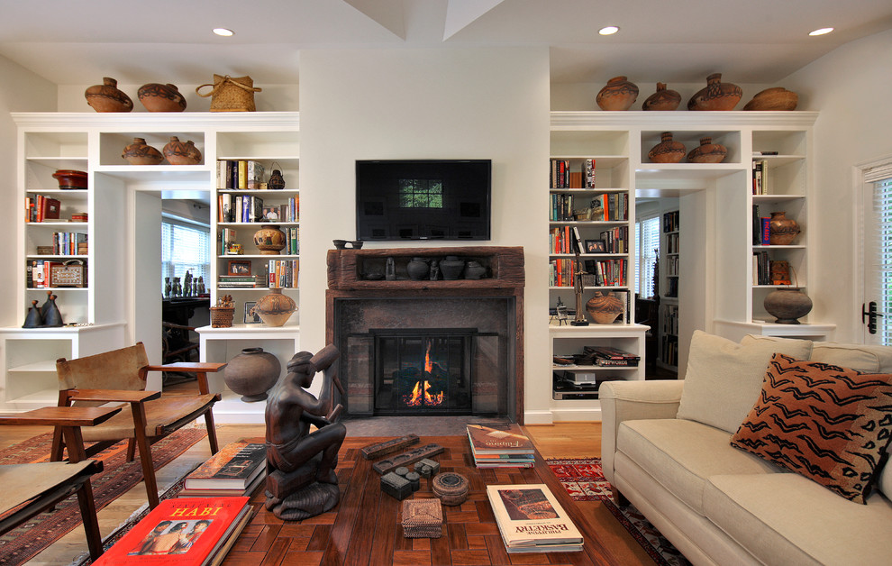 Esempio di un soggiorno classico con pareti beige, pavimento in legno massello medio, camino classico e TV a parete