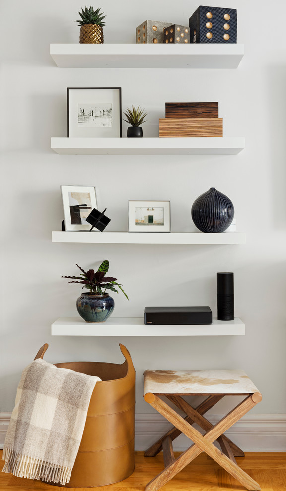 Immagine di un piccolo soggiorno design con pareti bianche, pavimento in legno massello medio e pavimento marrone