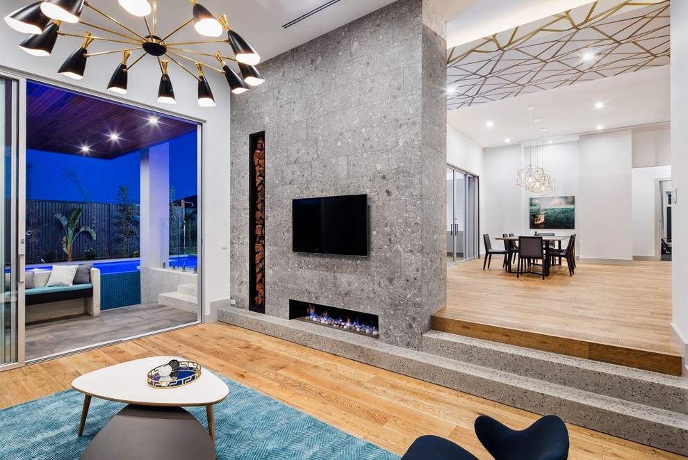 Large modern formal open plan living room in Adelaide with grey walls, light hardwood flooring, a tiled fireplace surround, a wall mounted tv, a hanging fireplace and brown floors.