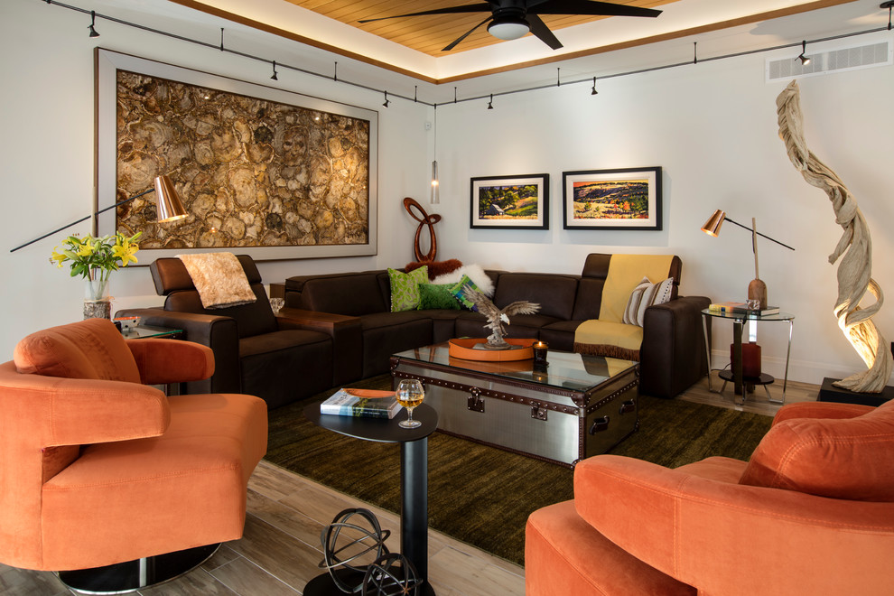 バンクーバーにある中くらいなトラディショナルスタイルのおしゃれなLDK (グレーの壁、淡色無垢フローリング、両方向型暖炉、石材の暖炉まわり、壁掛け型テレビ、茶色い床) の写真