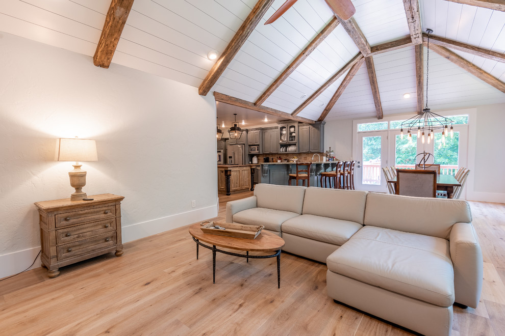 Offenes Landhausstil Wohnzimmer mit hellem Holzboden und freistehendem TV in Sonstige