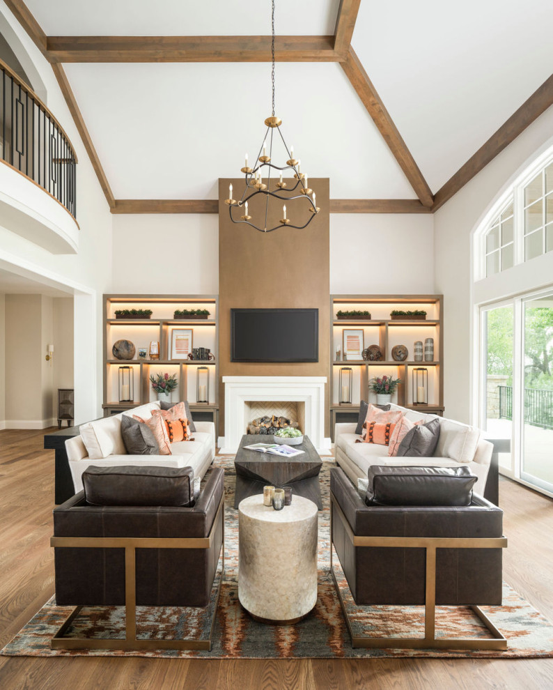 Inspiration for a large classic mezzanine living room in Denver with white walls, medium hardwood flooring, a standard fireplace, a stone fireplace surround, a wall mounted tv, beige floors and exposed beams.