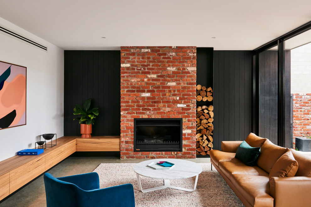 Mittelgroßes, Offenes Modernes Wohnzimmer mit Betonboden, Kamin, Kaminumrandung aus Backstein, grauem Boden, schwarzer Wandfarbe und Holzdielenwänden