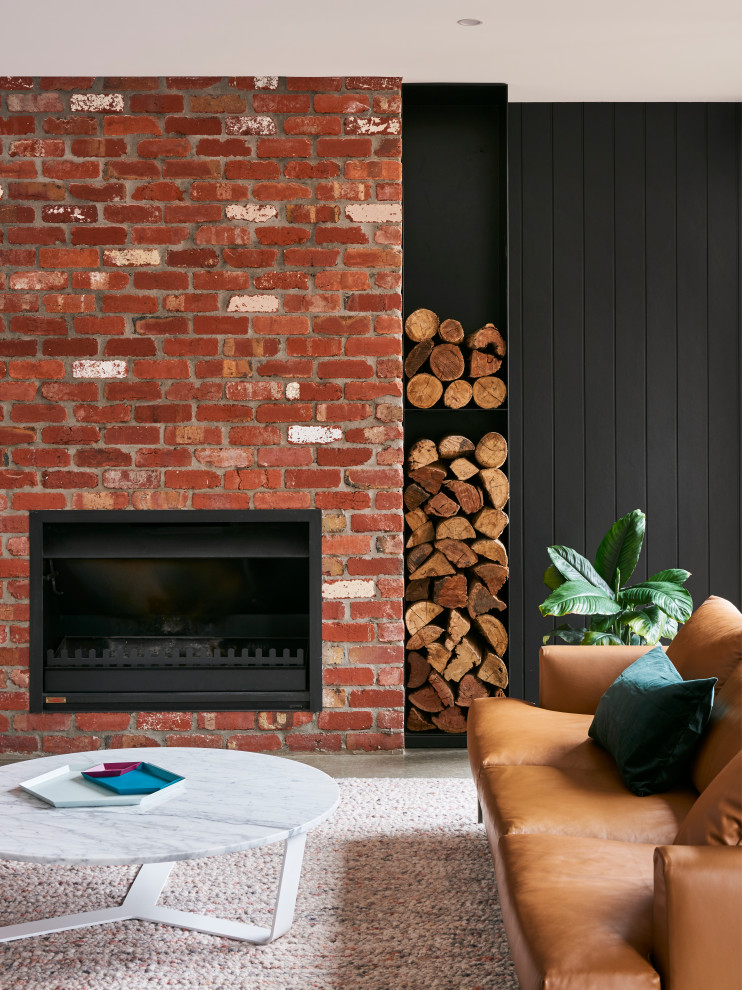 中くらいなモダンスタイルのおしゃれなLDK (白い壁、コンクリートの床、標準型暖炉、レンガの暖炉まわり、グレーの床) の写真