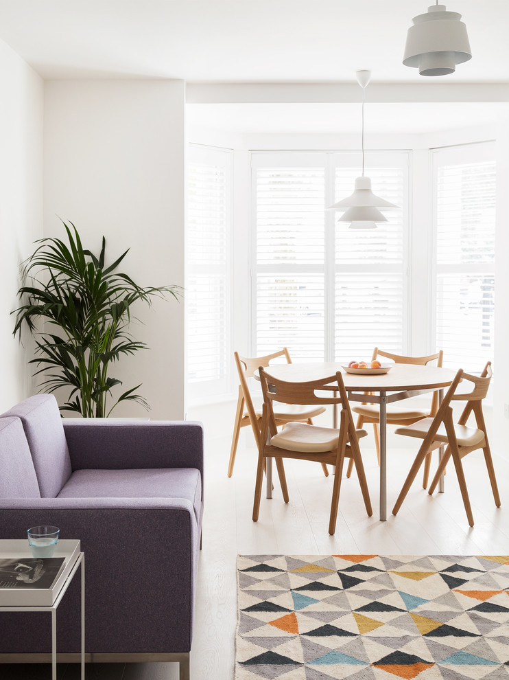 Small danish open concept light wood floor living room photo in London with white walls and a wall-mounted tv
