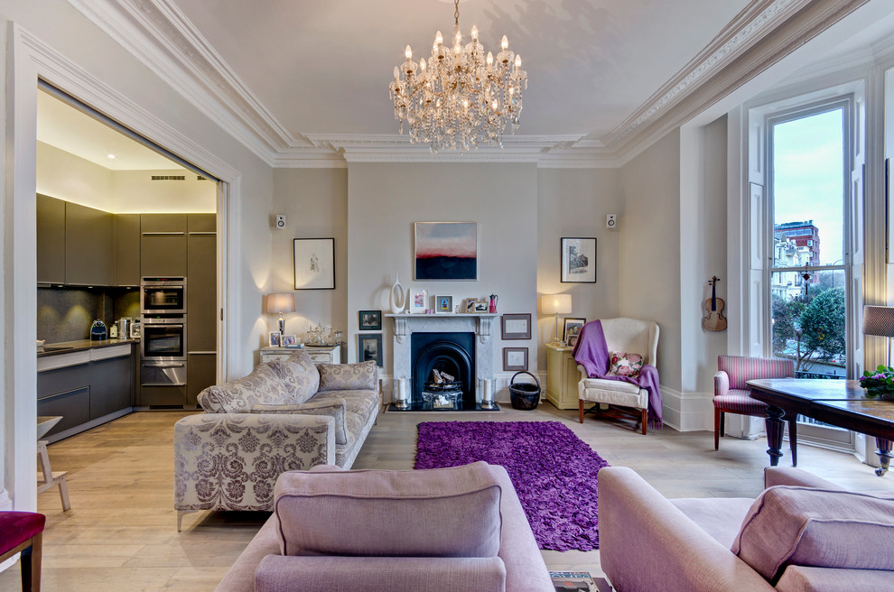 This is an example of a large traditional formal open plan living room in London with grey walls, light hardwood flooring, a standard fireplace, a stone fireplace surround and no tv.
