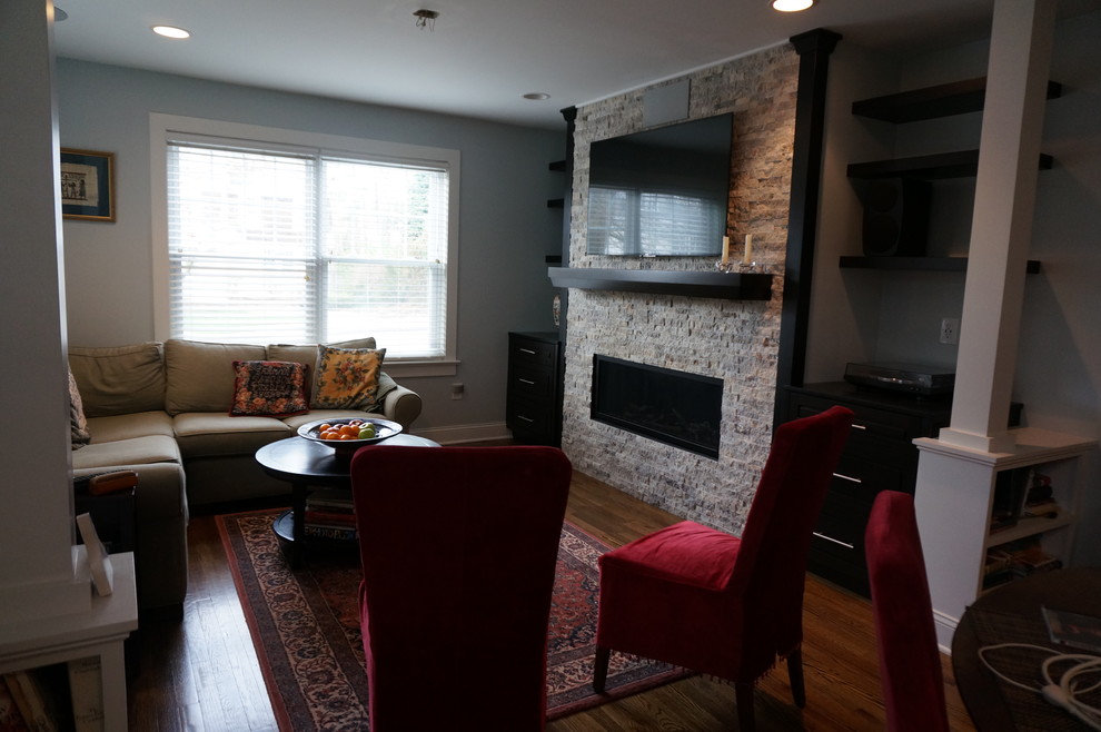 На фото: открытая гостиная комната среднего размера в стиле неоклассика (современная классика) с паркетным полом среднего тона, горизонтальным камином, фасадом камина из камня, телевизором на стене и синими стенами