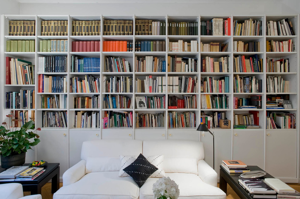 Idéer för funkis vardagsrum, med ett bibliotek, vita väggar och ljust trägolv