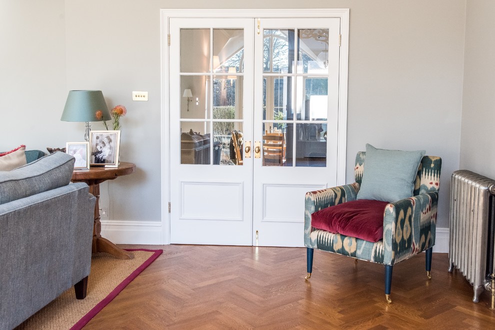 Mid-sized elegant open concept medium tone wood floor living room photo in London
