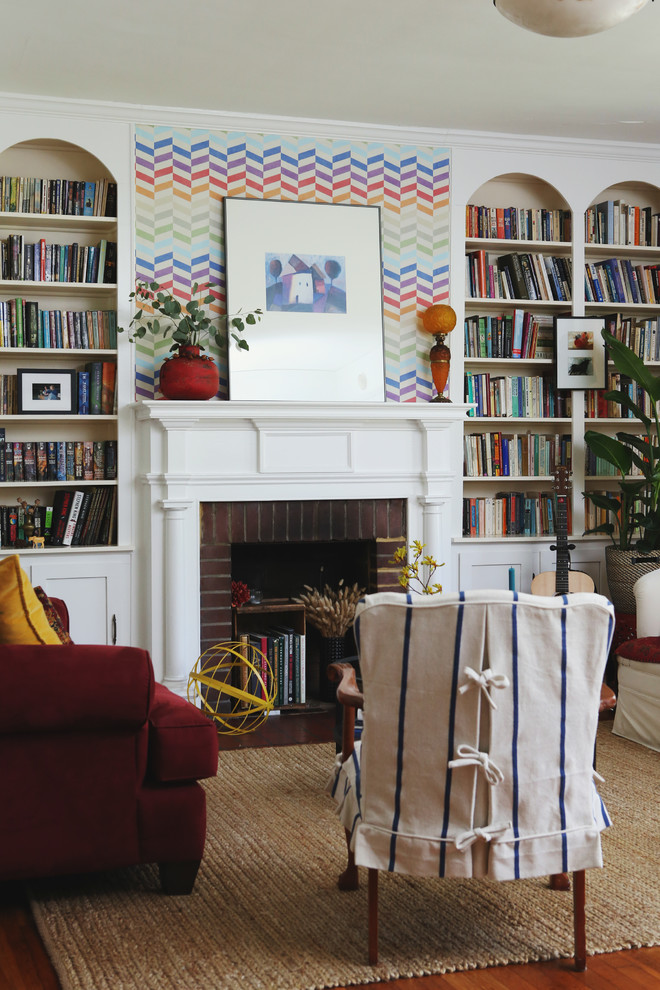 ローリーにあるエクレクティックスタイルのおしゃれなリビング (白い壁、無垢フローリング、標準型暖炉、レンガの暖炉まわり、茶色い床) の写真