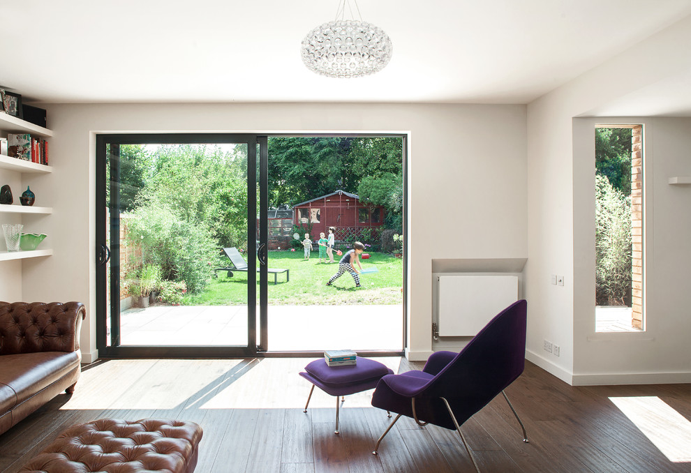 Diseño de salón abierto contemporáneo de tamaño medio con paredes blancas y suelo de madera en tonos medios