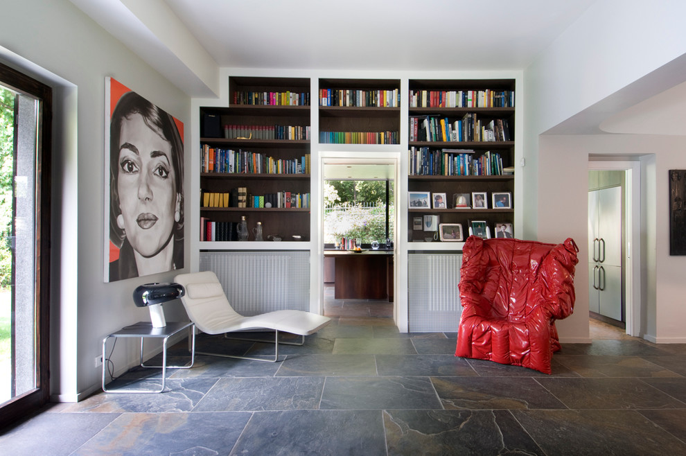This is an example of a contemporary open plan living room in Milan with slate flooring and a reading nook.