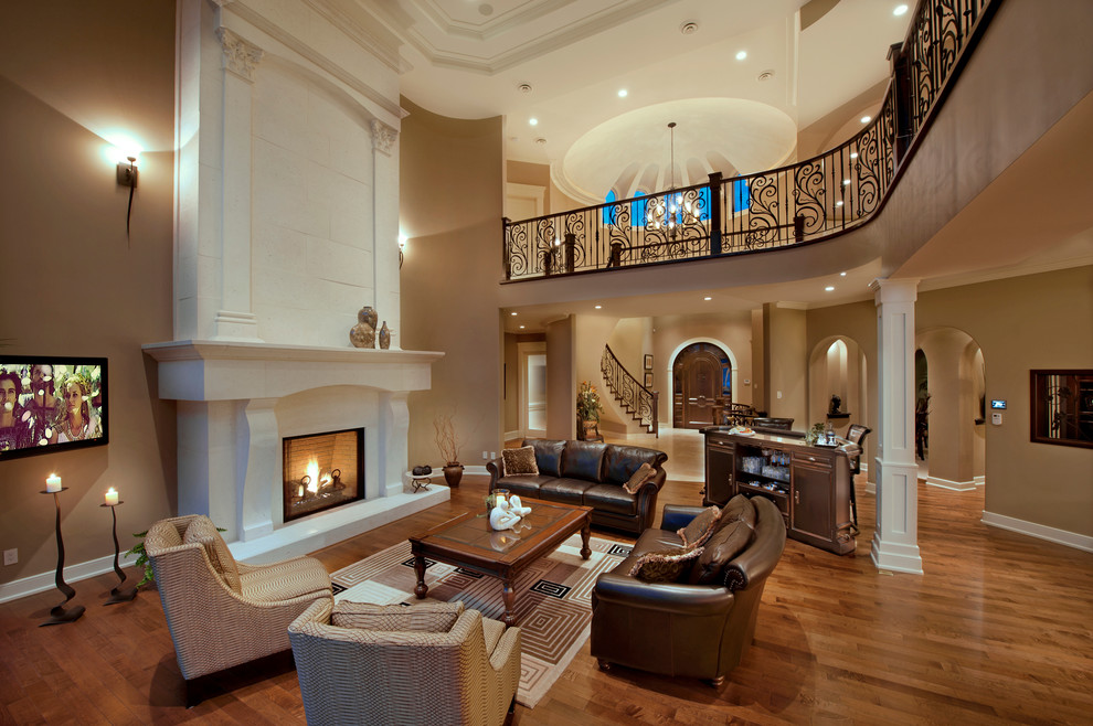 Пример оригинального дизайна: парадная, открытая гостиная комната в средиземноморском стиле с коричневыми стенами, темным паркетным полом, стандартным камином и телевизором на стене