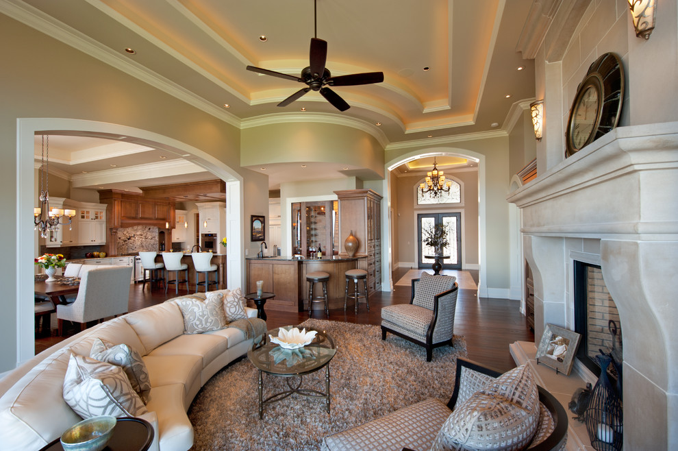 Пример оригинального дизайна: гостиная комната в классическом стиле с домашним баром, бежевыми стенами и стандартным камином