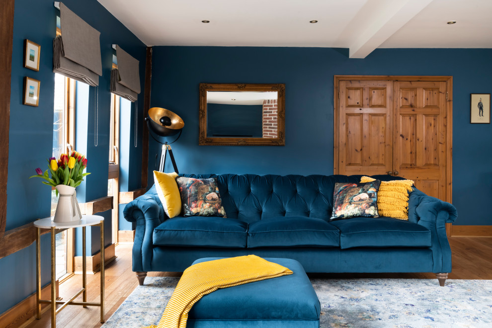 Cette photo montre un grand salon éclectique fermé avec une salle de réception, un mur bleu, un sol en bois brun, une cheminée standard, un manteau de cheminée en brique, un téléviseur dissimulé, un sol marron, un plafond à caissons et du papier peint.