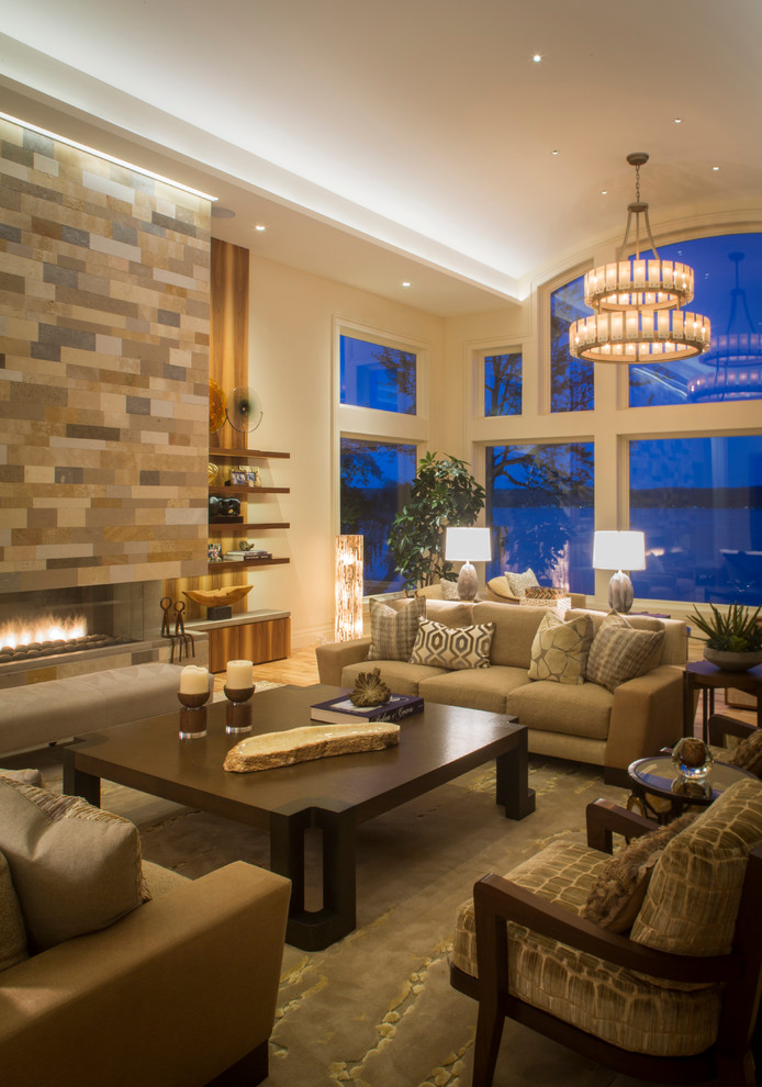 Photo of a large traditional formal open plan living room in Miami with beige walls, a ribbon fireplace, medium hardwood flooring, a stone fireplace surround, no tv and feature lighting.