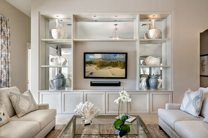 Example of a transitional open concept travertine floor living room design in Miami with beige walls and a media wall