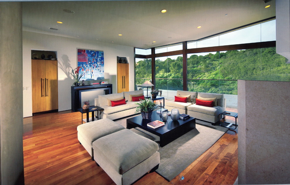 Esempio di un ampio soggiorno minimal aperto con pareti bianche, pavimento in legno massello medio e nessuna TV
