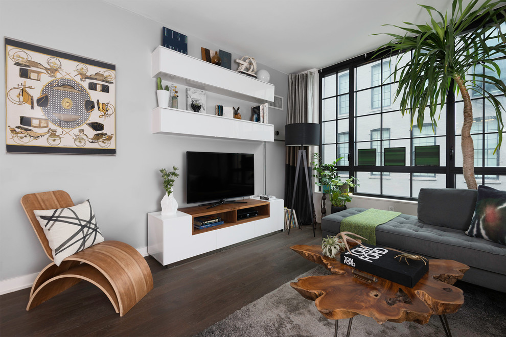 Diseño de salón actual sin chimenea con paredes grises, suelo de madera oscura y televisor independiente
