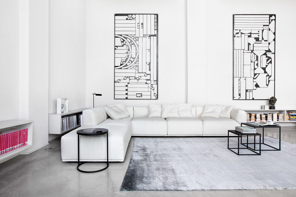 Immagine di un grande soggiorno minimal con pareti bianche, pavimento in cemento e nessun camino