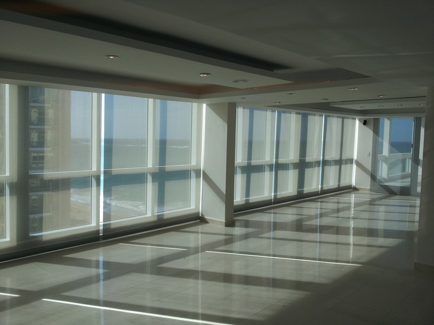 Imagen de salón para visitas cerrado contemporáneo de tamaño medio con paredes beige, suelo marrón, suelo de mármol y televisor retractable