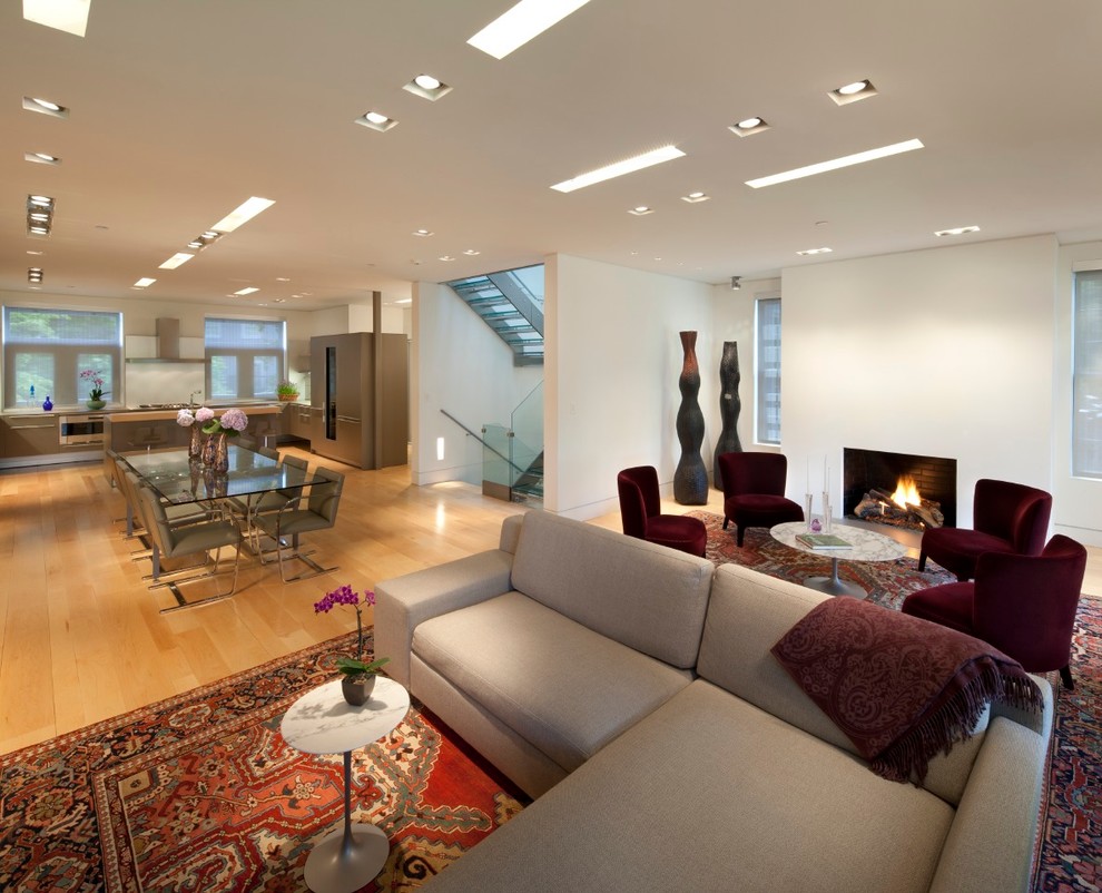 Photo of a large contemporary formal open plan living room in Philadelphia with white walls, light hardwood flooring, a standard fireplace and a plastered fireplace surround.