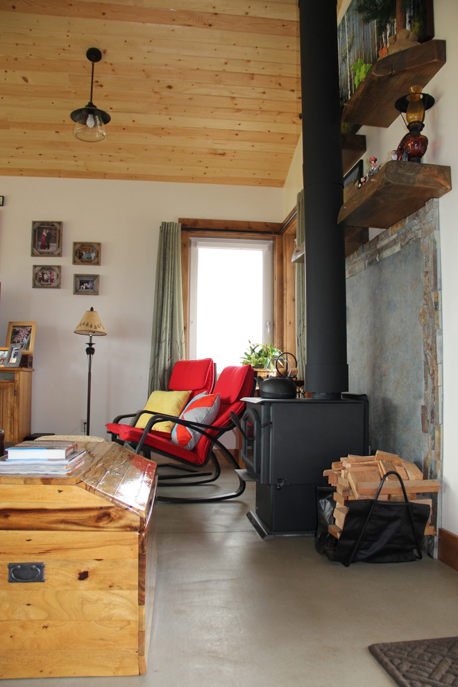 Cette photo montre un salon nature de taille moyenne et ouvert avec un mur blanc, sol en béton ciré, une cheminée standard, un manteau de cheminée en pierre et un téléviseur indépendant.