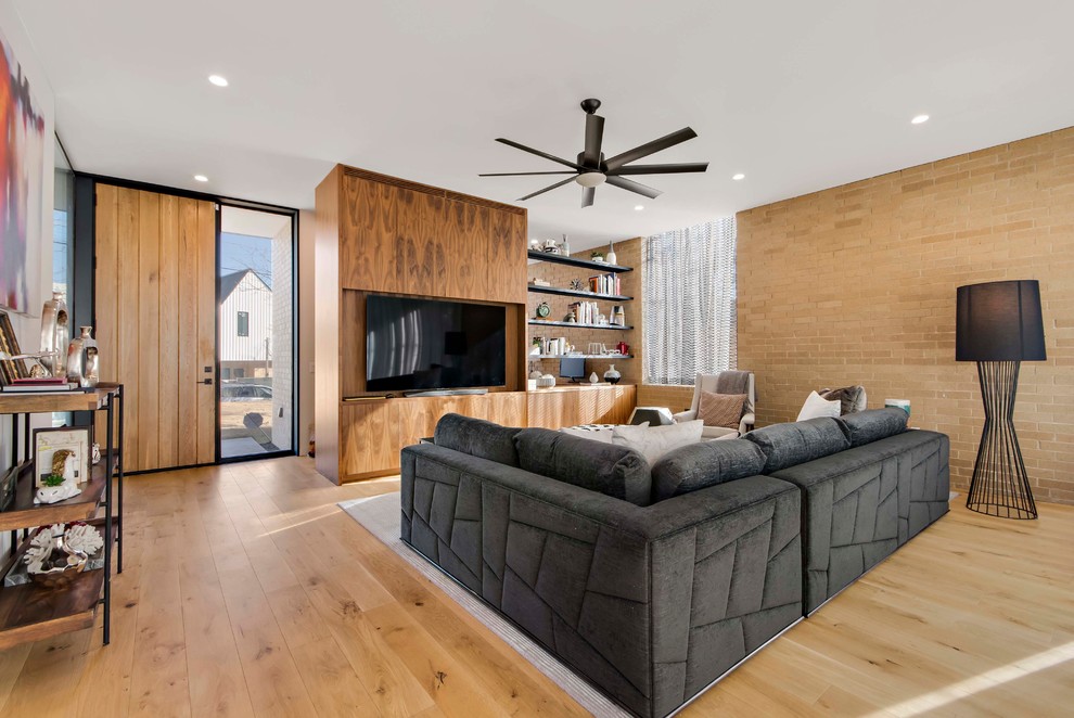 Großes, Offenes Modernes Wohnzimmer ohne Kamin mit beiger Wandfarbe, hellem Holzboden, Multimediawand und beigem Boden in Austin