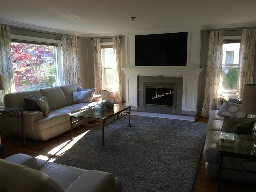 Example of a minimalist light wood floor living room design in Boston with a standard fireplace, a stone fireplace and a concealed tv