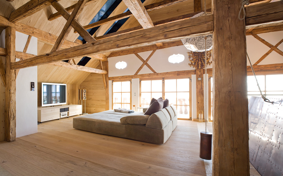 Diseño de salón abierto rural de tamaño medio con suelo de madera clara, televisor independiente y paredes blancas