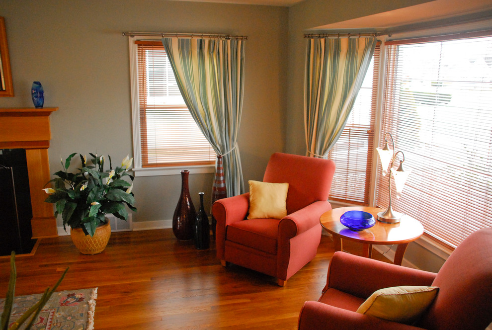 Пример оригинального дизайна: большая изолированная гостиная комната в классическом стиле с зелеными стенами, паркетным полом среднего тона, стандартным камином и фасадом камина из дерева