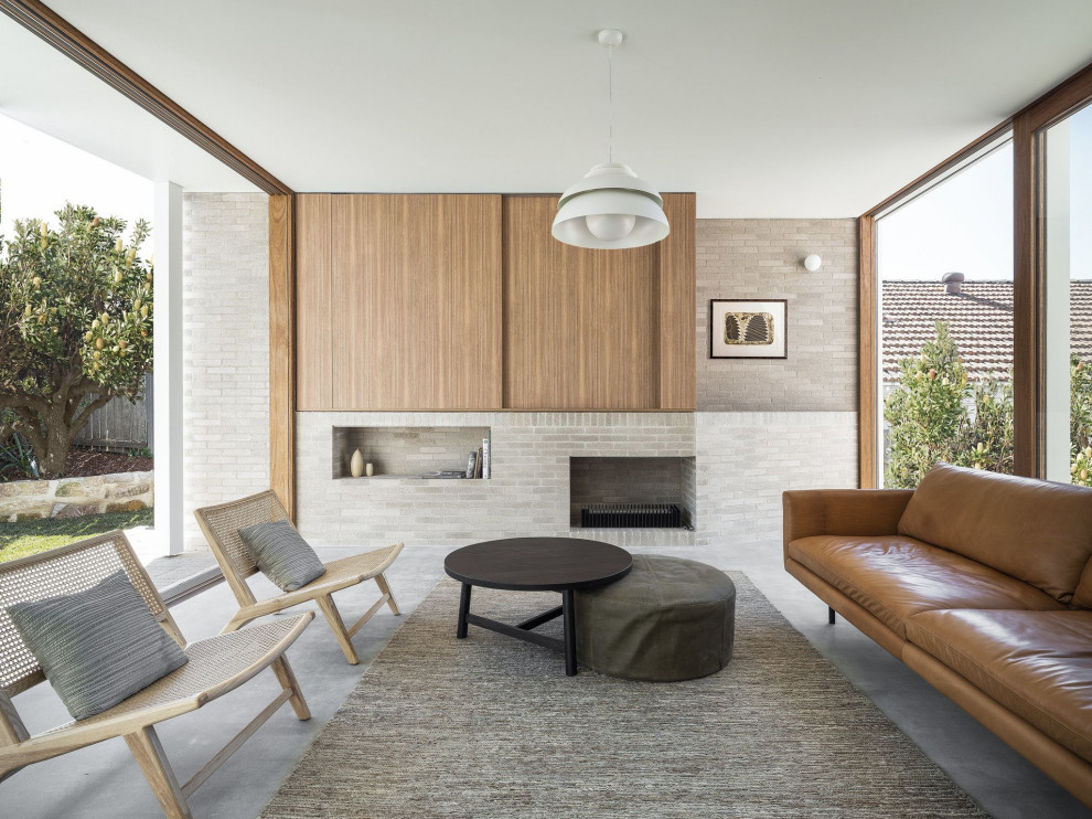 Großes, Repräsentatives, Fernseherloses, Offenes Modernes Wohnzimmer mit grauer Wandfarbe, Kamin, Kaminumrandung aus Backstein und grauem Boden in Sydney