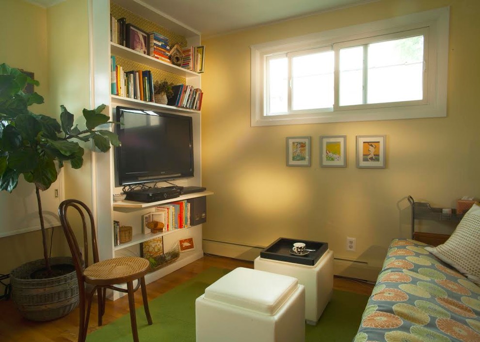Modelo de salón cerrado clásico pequeño con paredes amarillas, suelo de madera clara y pared multimedia
