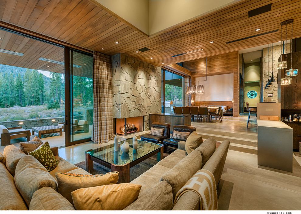 Large contemporary open plan living room in Sacramento with concrete flooring, a corner fireplace, a stone fireplace surround and grey floors.
