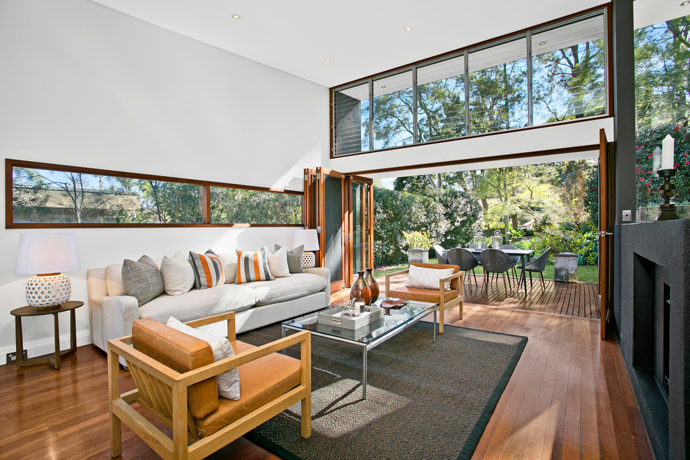 Modernes Wohnzimmer mit weißer Wandfarbe, braunem Holzboden und Kamin in Sydney