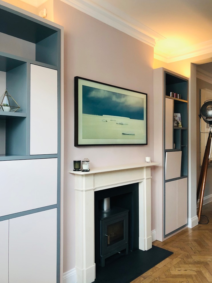 Cette photo montre un grand salon moderne ouvert avec un bar de salon, un poêle à bois, un manteau de cheminée en pierre, un téléviseur encastré et un sol marron.