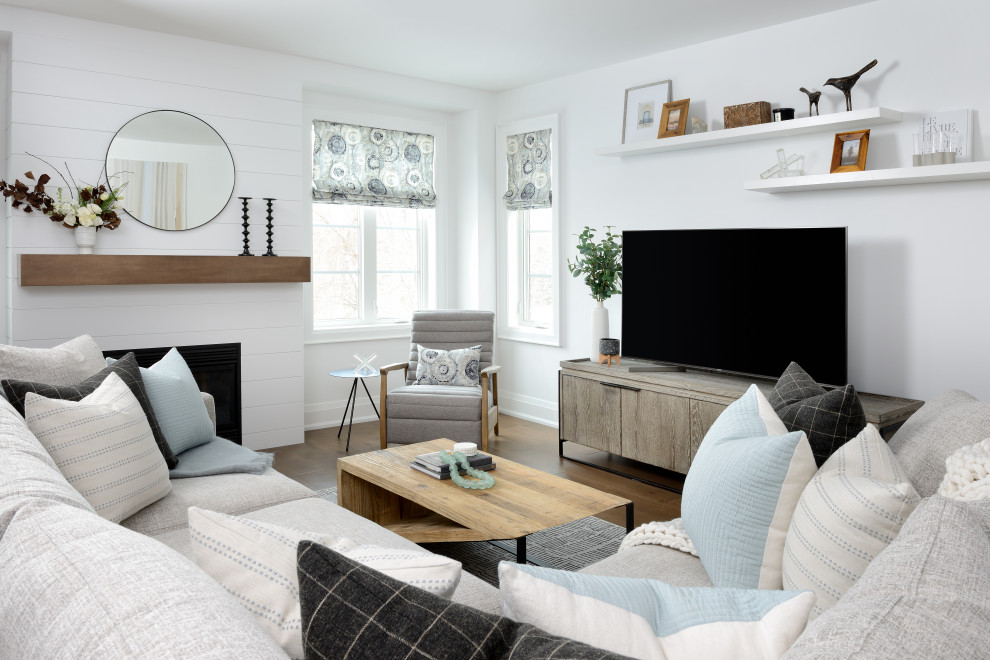 Großes, Offenes Klassisches Wohnzimmer mit weißer Wandfarbe, braunem Holzboden, Kamin, Kaminumrandung aus Holzdielen, freistehendem TV und braunem Boden in Toronto