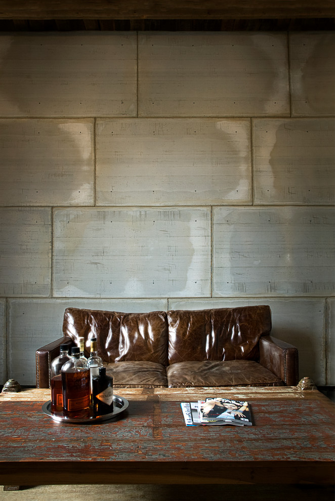 Foto di un soggiorno contemporaneo con angolo bar, pareti grigie, pavimento in cemento e nessuna TV