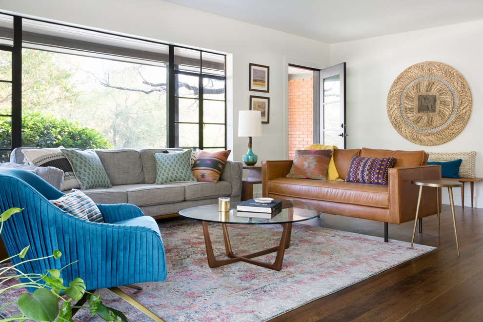 This is an example of a bohemian living room in Austin with white walls, dark hardwood flooring and brown floors.