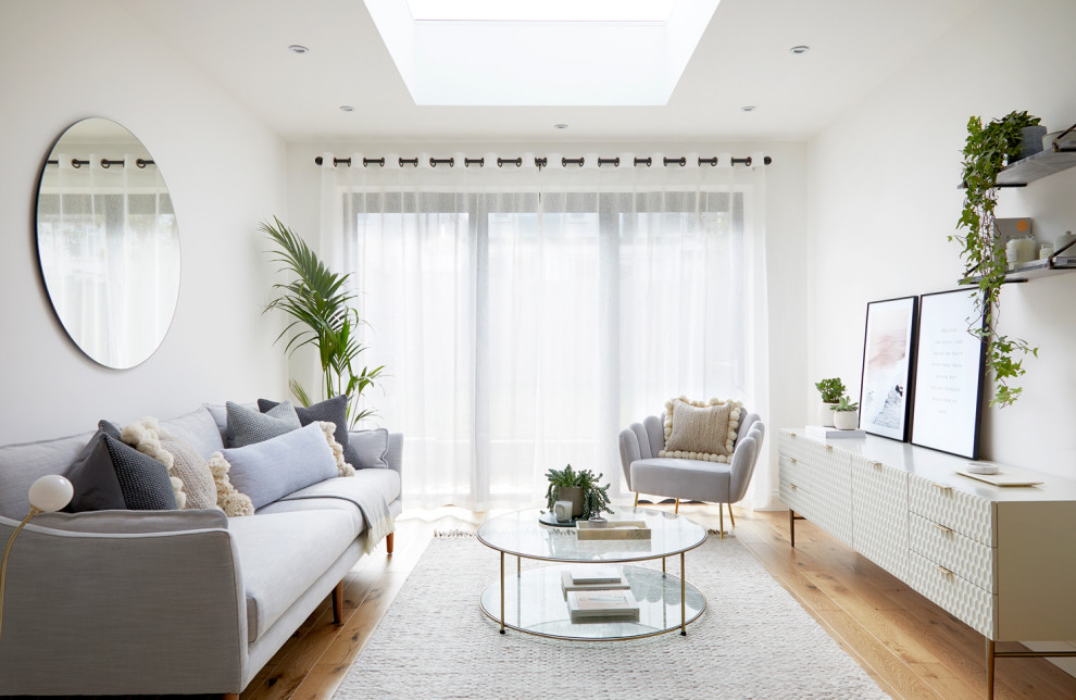 Inspiration for a scandinavian living room in London with white walls, medium hardwood flooring and brown floors.