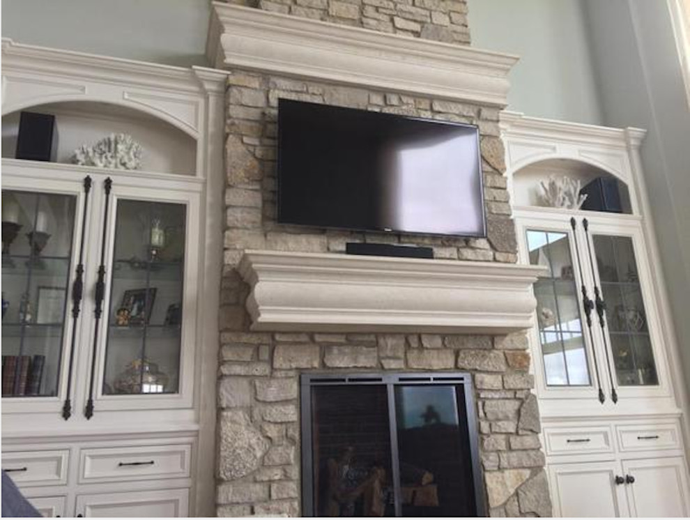 Mid-sized transitional enclosed living room photo in Cleveland with gray walls, a standard fireplace, a stone fireplace and a media wall