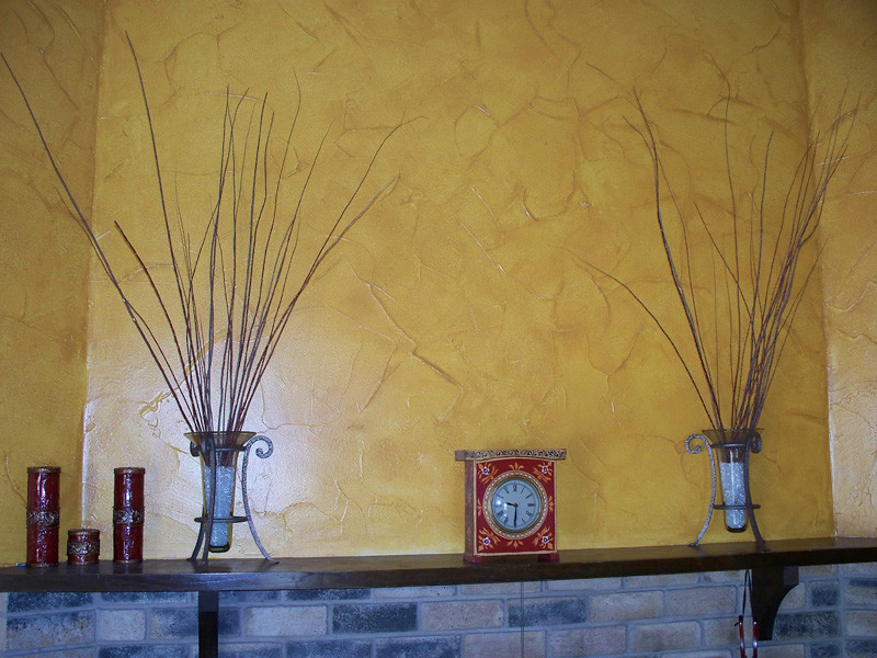 Cette photo montre un salon chic de taille moyenne avec un mur jaune, une cheminée standard et un manteau de cheminée en brique.