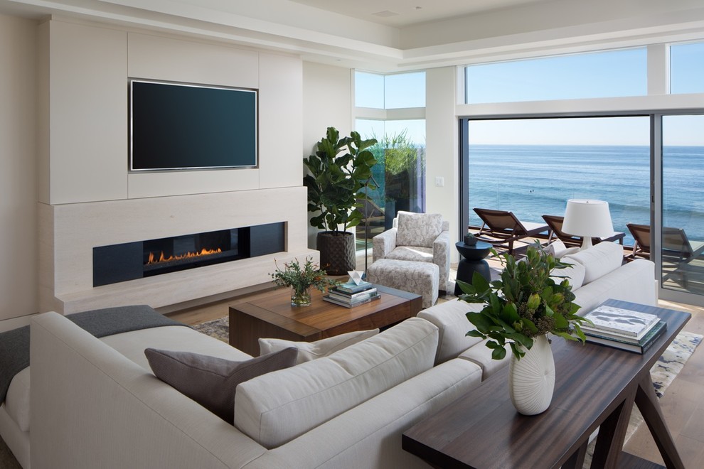 Свежая идея для дизайна: гостиная комната в современном стиле с белыми стенами, паркетным полом среднего тона, горизонтальным камином, телевизором на стене и коричневым полом - отличное фото интерьера