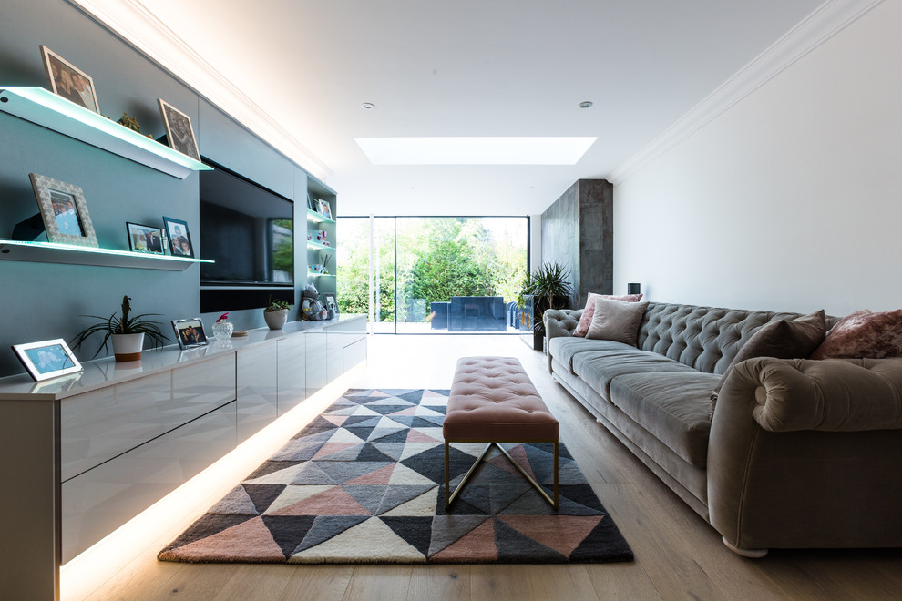 Offenes Modernes Wohnzimmer mit weißer Wandfarbe, Multimediawand, hellem Holzboden und beigem Boden in London