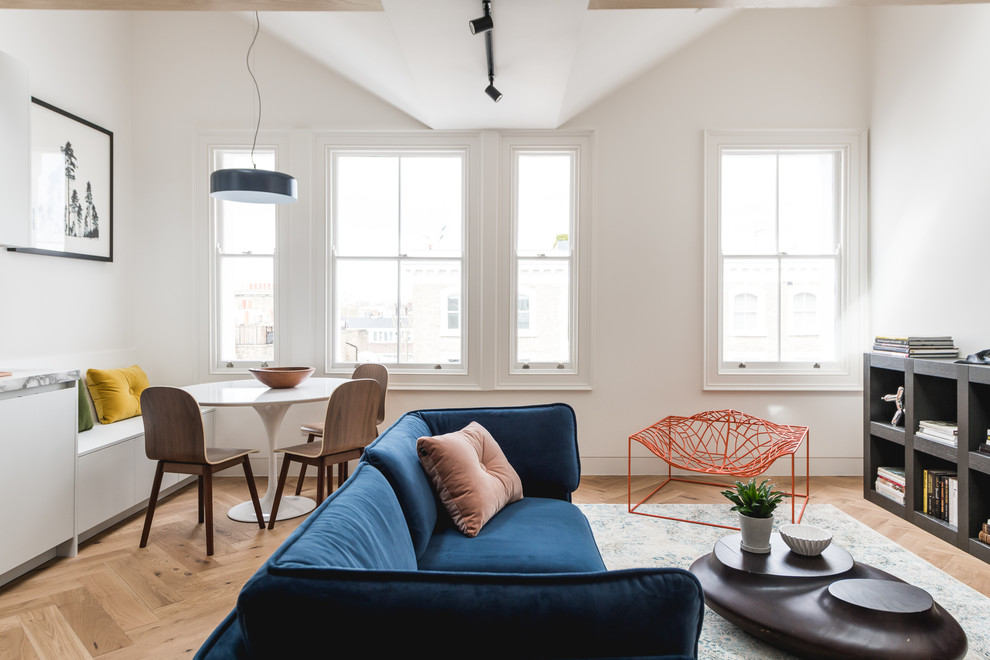 Esempio di un piccolo soggiorno design con pareti bianche, parquet chiaro e pavimento marrone