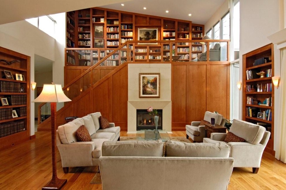 На фото: гостиная комната в современном стиле с с книжными шкафами и полками