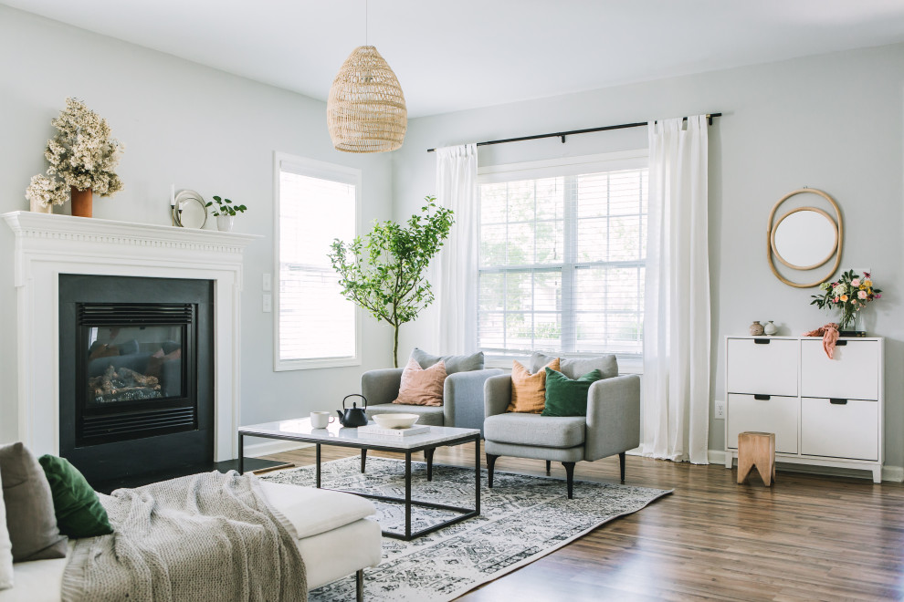 This is an example of a medium sized scandinavian open plan living room in Raleigh with grey walls, laminate floors, a standard fireplace, no tv and brown floors.