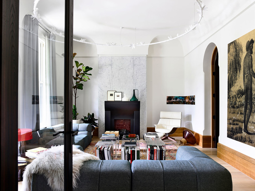 Esempio di un soggiorno moderno con pareti bianche, parquet chiaro, camino classico e pavimento beige