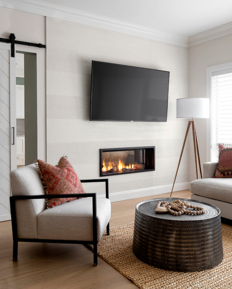 Mittelgroßes Klassisches Wohnzimmer mit beiger Wandfarbe, braunem Holzboden, Tunnelkamin, Kaminumrandung aus Metall, TV-Wand und beigem Boden in Vancouver